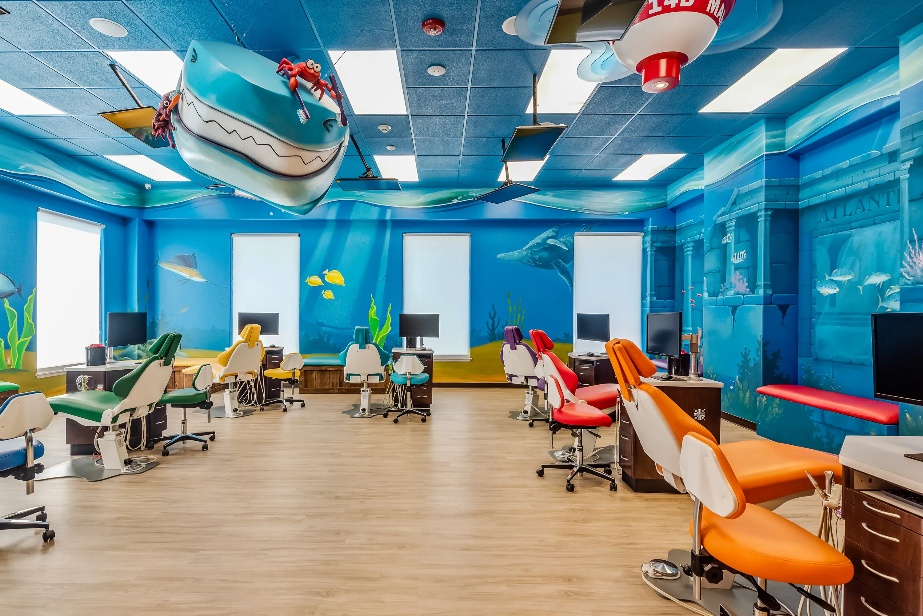 The open bay with a shark suspended from the ceiling and underwater murals