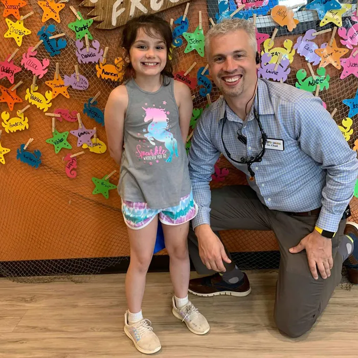 Dr. Jensen with a Cavity Free Club winner in front of the wall